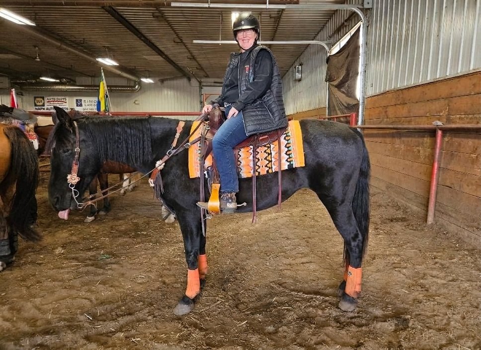 Melissa riding in an indoor arena